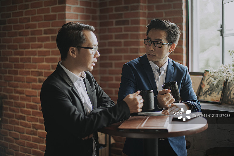 两名亚裔华人白领咖啡歇息讨论图片素材