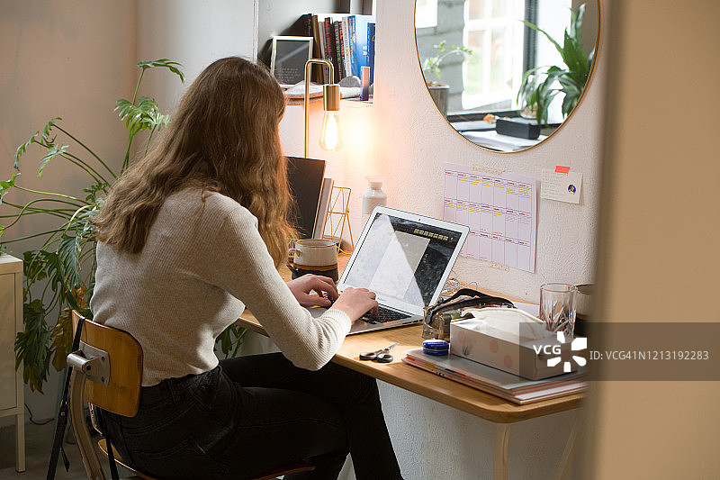 青少年在房间里用笔记本电脑做作业图片素材