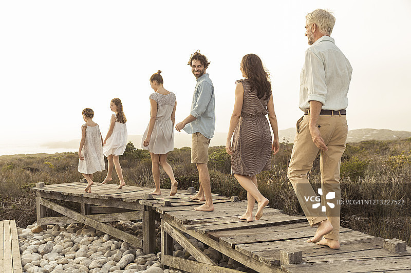 一家人在木板路上欣赏日落图片素材