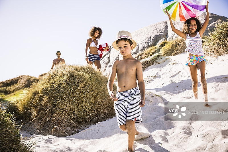 一家人穿过沙丘走向海滩图片素材