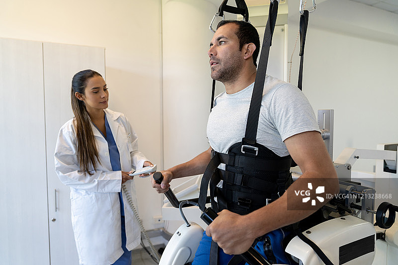 在理疗师指导下，进行外骨骼康复训练的病人图片素材