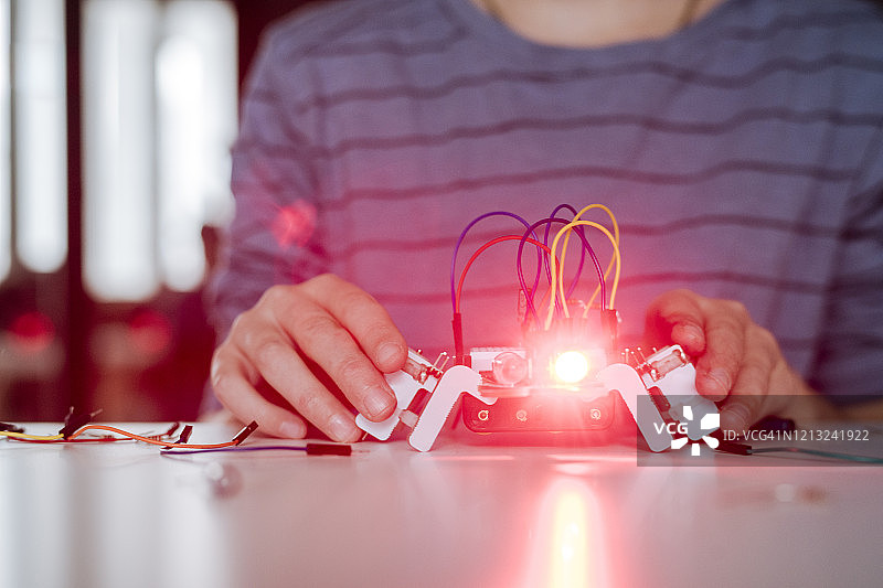 男孩的手组装机器人，红灯图片素材