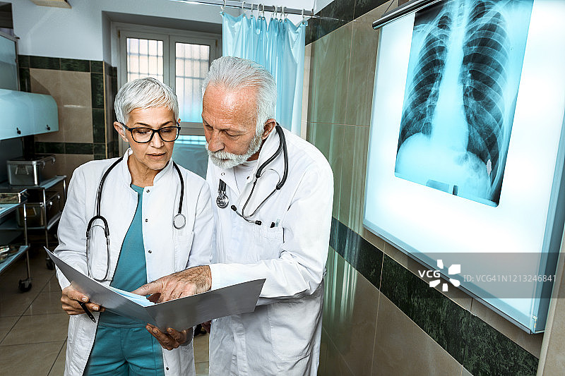 两位经验丰富的医生检查新冠感染患者的胸部X光片，了解其既往病史图片素材