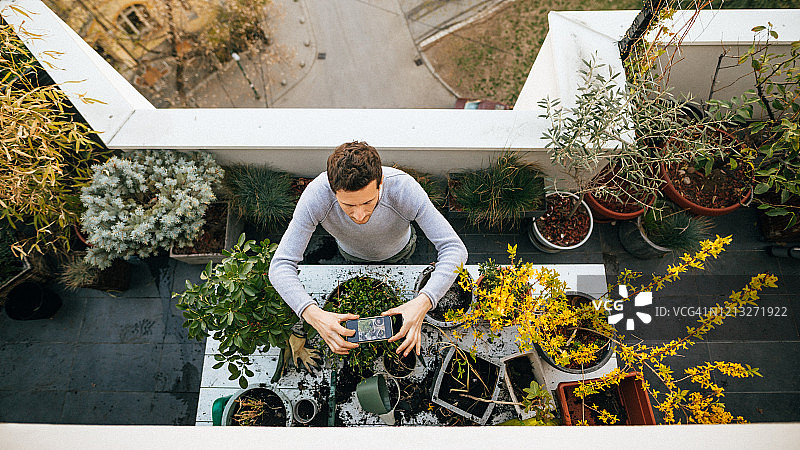 年轻男人拍摄他的植物图片素材