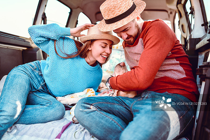 情侣和他们的狗在小型货车里玩耍图片素材