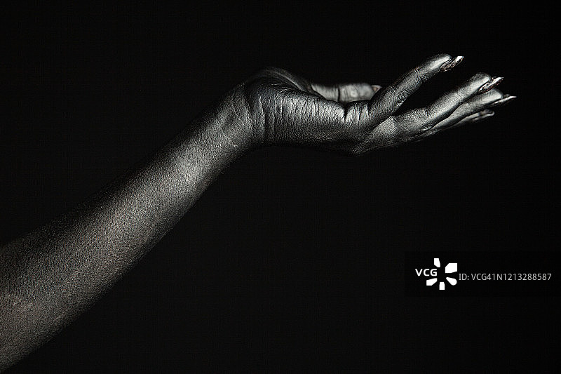 涂成黑色的女人手，带有黑色美甲，像是怪物身体的一部分图片素材