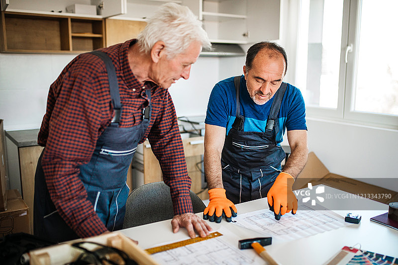 两位年长的维修工试图弄清楚如何组装家具图片素材