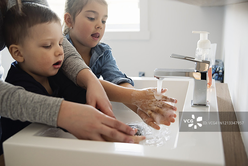 疫情隔离期间母亲教幼儿洗手图片素材