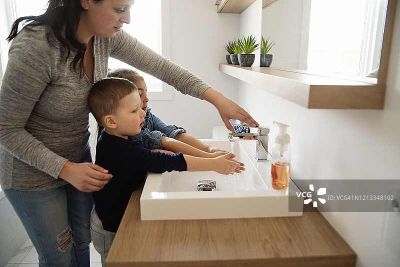 疫情隔离期间母亲教幼儿洗手图片素材