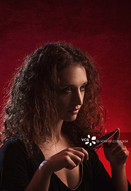 手持匕首的红发卷发女子图片素材