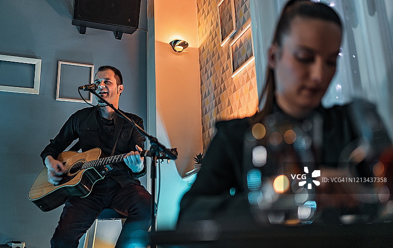 男子在舞台上弹吉他唱歌图片素材