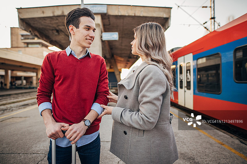 站在火车站台上交谈的年轻夫妇图片素材
