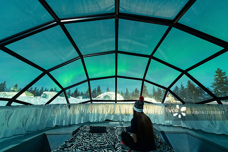 从玻璃穹顶小屋看到的夜空中闪耀的北极光图片素材