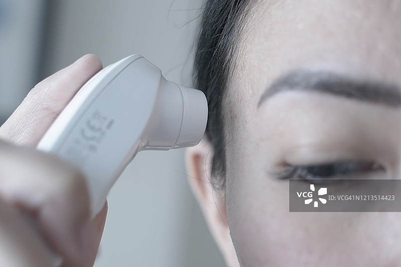 隔离期间检查治疗新冠病毒的女人体温图片素材