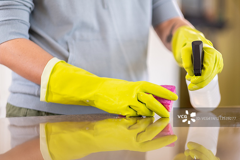女人用消毒剂和海绵擦拭台面图片素材
