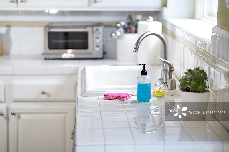 带肥皂、海绵和刷子的厨房水槽和台面图片素材