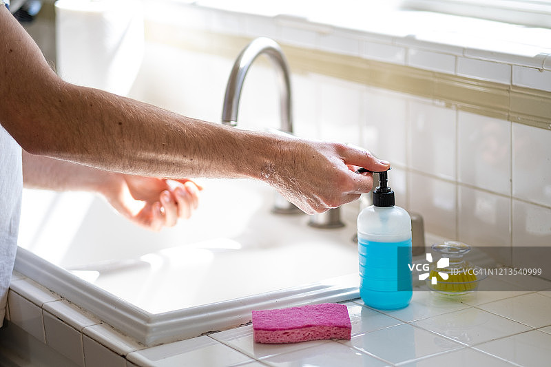 男子在厨房水槽洗手图片素材