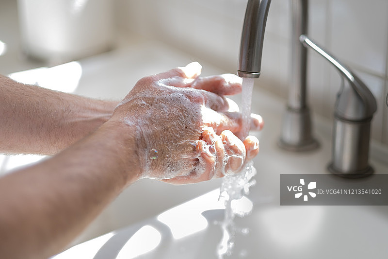 男子在厨房水槽洗手图片素材
