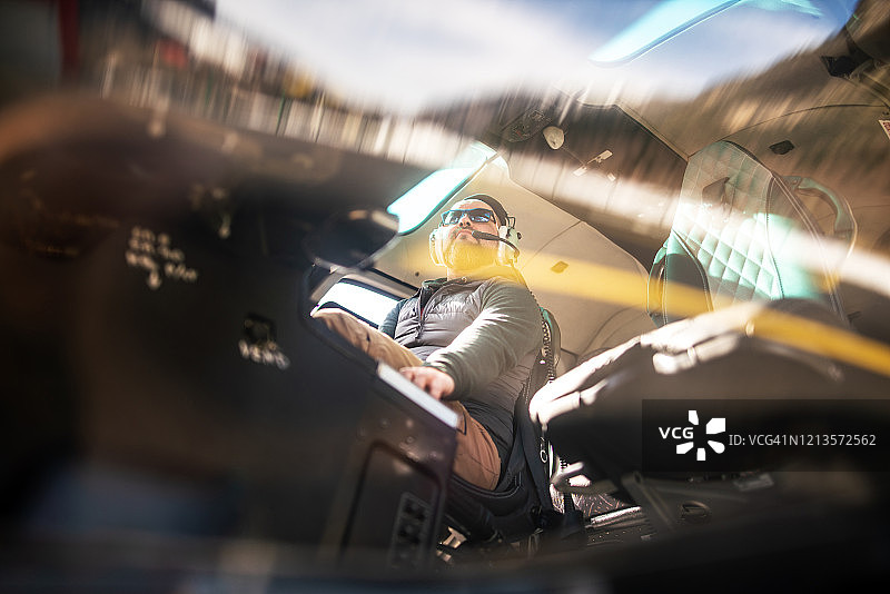 男子在直升机驾驶舱内进行飞行前检查图片素材