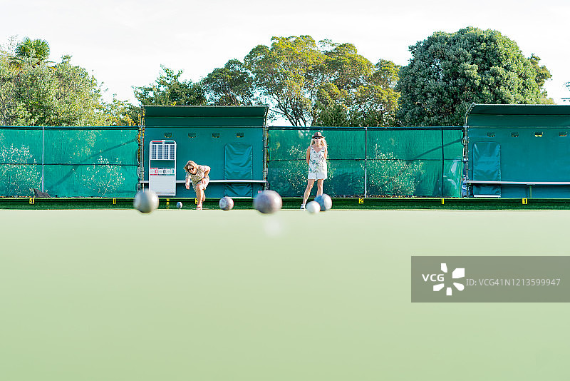 两位年长的女性朋友在户外玩社交草地滚球图片素材