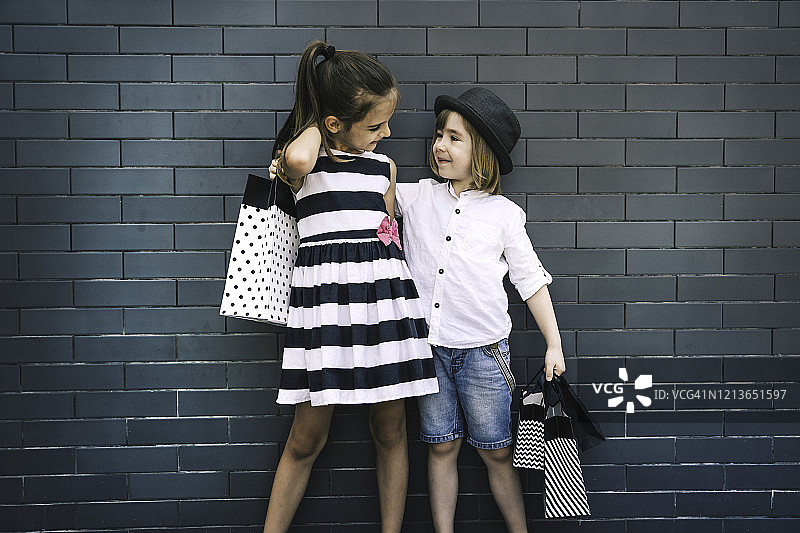 拿着购物袋的可爱儿童，购物消费概念图片素材