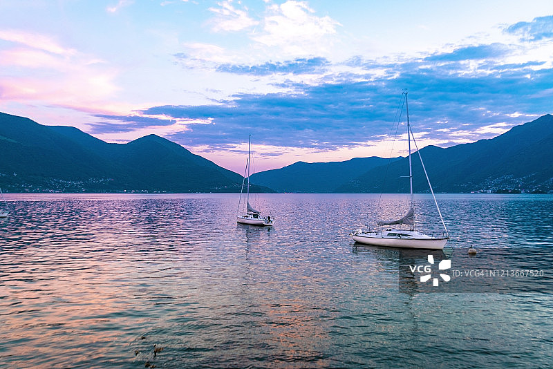 日落时分，洛迦诺湖与帆船和群山图片素材