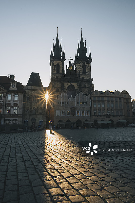 日出时在捷克共和国布拉格老城广场行走的女人图片素材