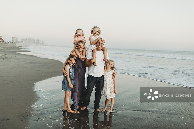 在海滩阳光下微笑的全家福图片素材