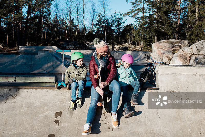 妈妈和孩子们在滑板公园户外阳光下玩耍图片素材