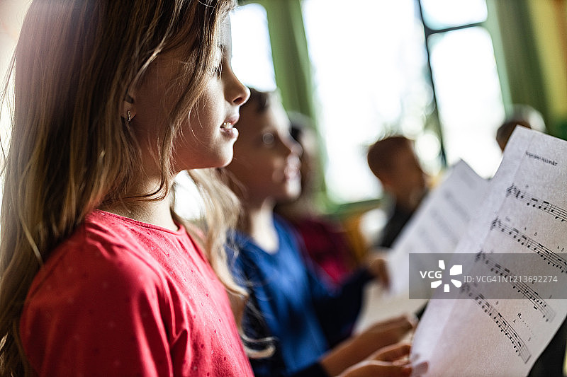 课堂上练习乐谱的女学生图片素材