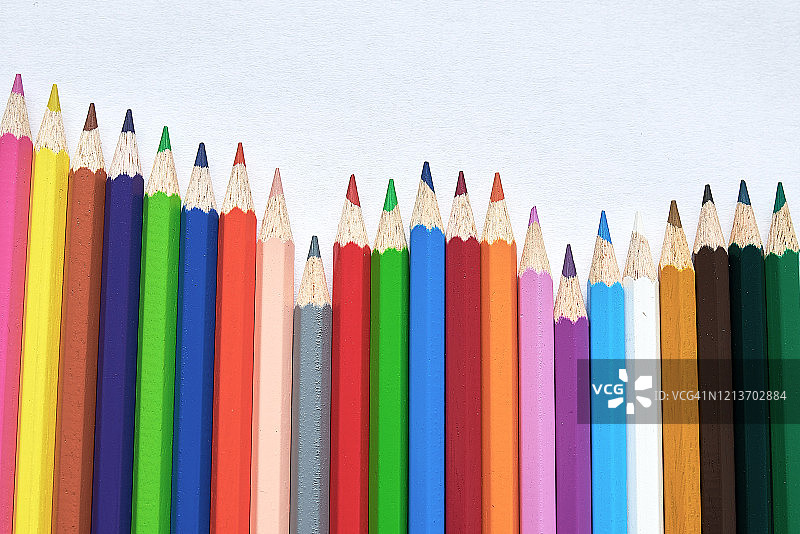 一组彩色铅笔排列成三角形，一支引领着队伍图片素材
