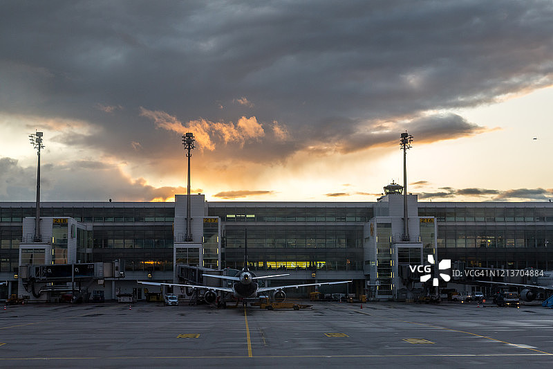 停靠在慕尼黑机场航站楼的飞机（日落）图片素材
