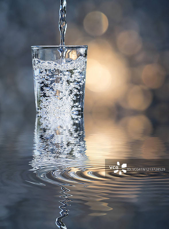 在户外溢出的玻璃杯中倒水图片素材