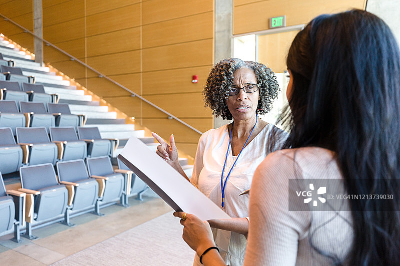 严肃的大学教授讨论学生的成绩图片素材