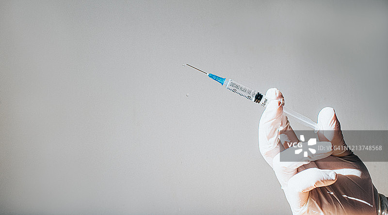 戴手套的手拿着注射器图片素材