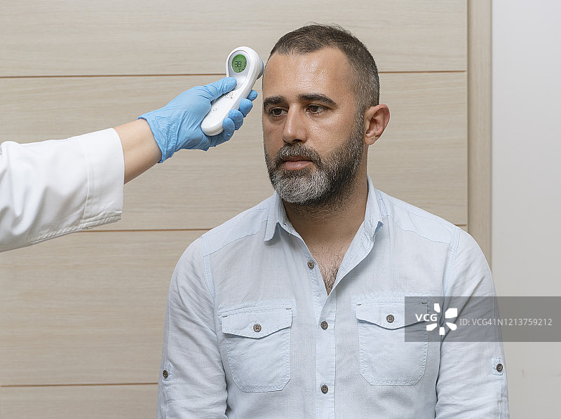 女医生在医院用红外工具为病人检查体温图片素材