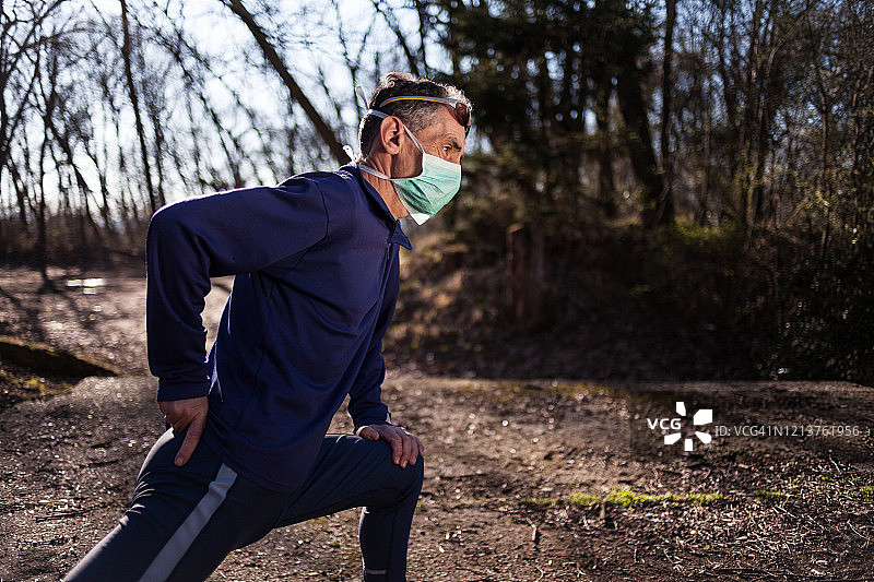老年男人戴着口罩在公园跑步图片素材