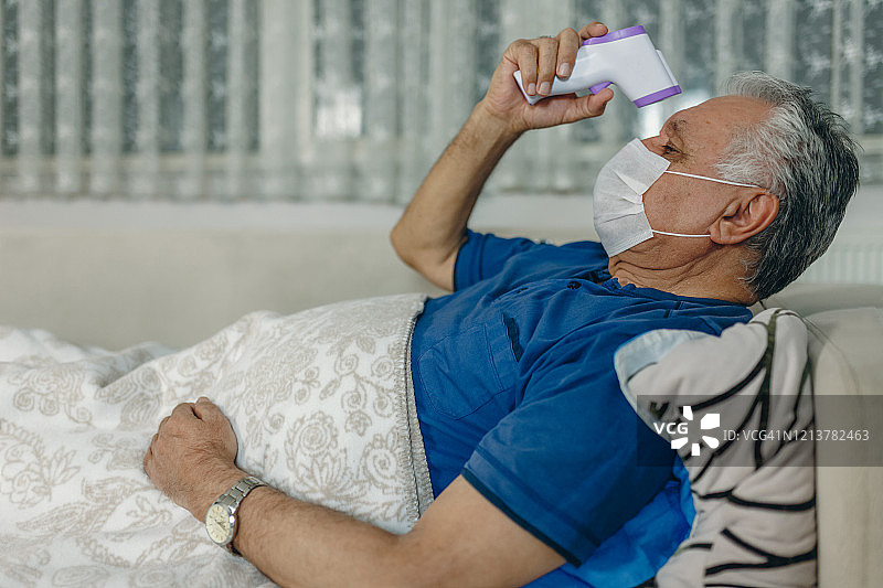 居家观察的病人测量体温图片素材