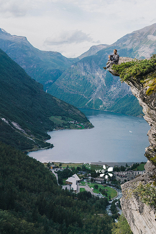 男子坐在挪威盖朗厄尔峡湾附近的岩石上图片素材