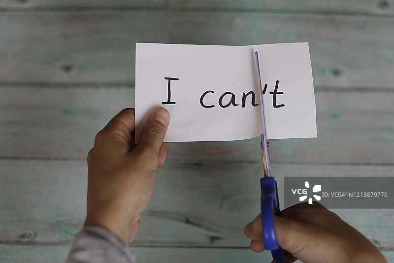 用剪刀剪写着“我不可以”字样的纸图片素材