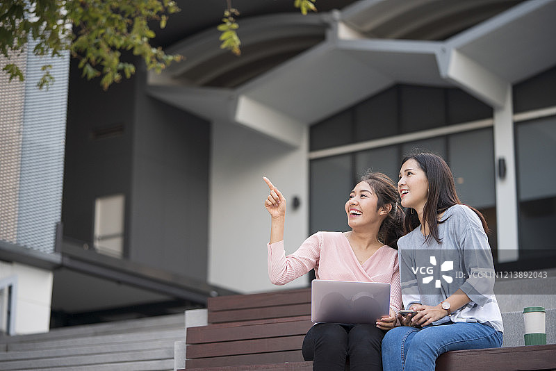 坐在台阶上使用笔记本电脑的小女孩图片素材