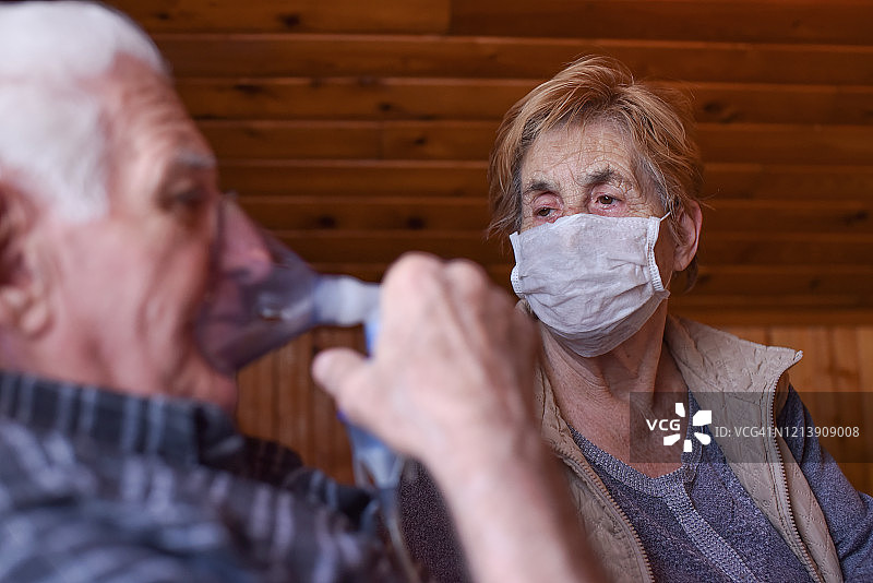 新冠疫情期间，老年人使用呼吸设备，妻子戴呼吸面罩互相照顾图片素材