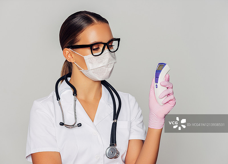 女医生手持红外线温度计图片素材