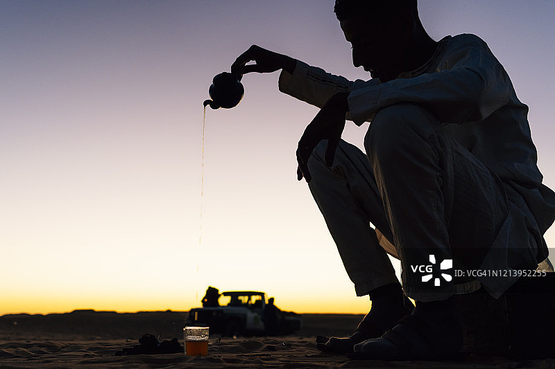 在撒哈拉沙漠廷杜夫准备茶的男人轮廓，阿尔及利亚图片素材
