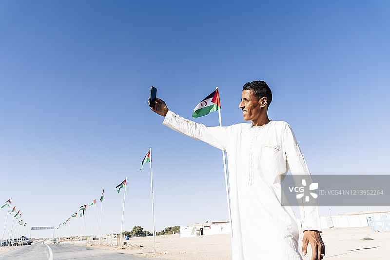 在阿尔及利亚斯马拉难民营用手机自拍的男人图片素材