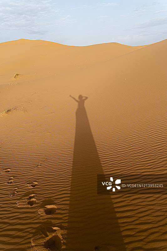 摩洛哥梅尔祖卡撒哈拉沙漠沙丘上女人的影子图片素材
