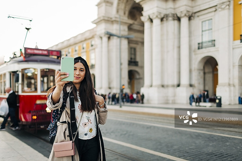年轻女游客在葡萄牙里斯本商业广场自拍图片素材