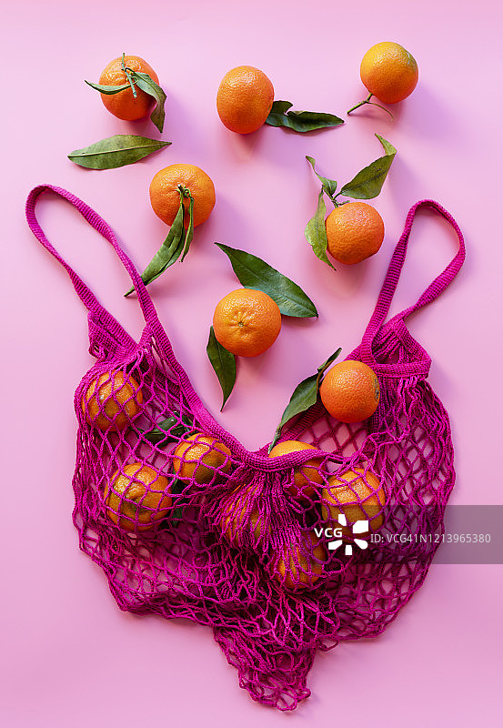 成熟的克莱门汀橘和环保可重复使用网袋的影棚照片图片素材
