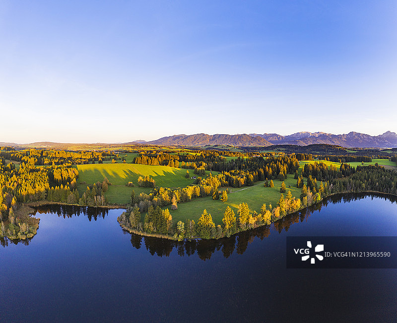 德国巴伐利亚，罗绍普滕，秋季施穆特韦厄湖森林覆盖的岸边无人机景观图片素材