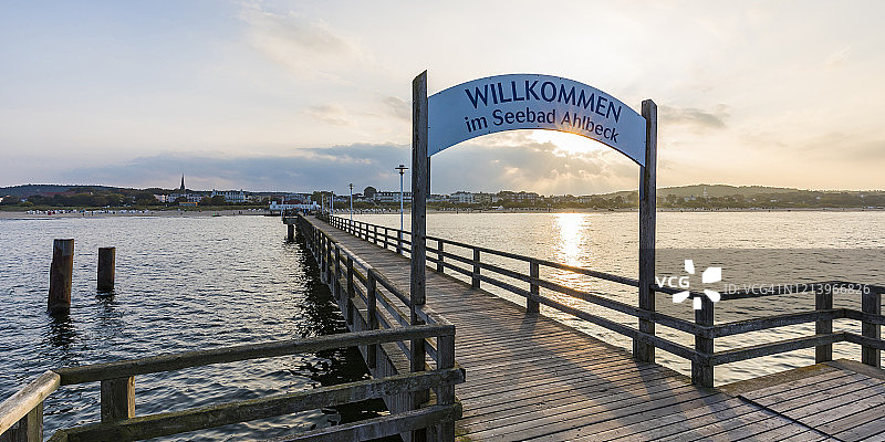 德国梅克伦堡-前波美拉尼亚州黑灵斯多夫，日落时分空荡荡的木制码头上的欢迎标志图片素材